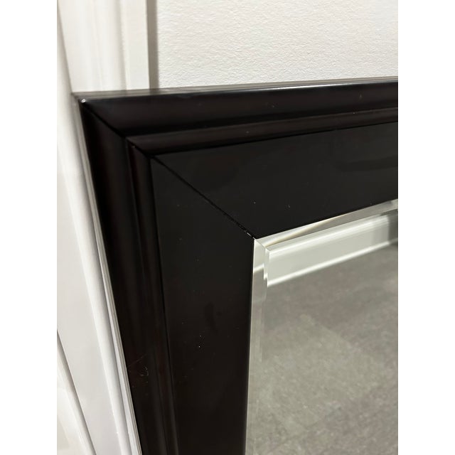 A large rectangular mirror in a dark wood frame with a beveled glass edge. Originally mounted atop a dresser, this mirror...