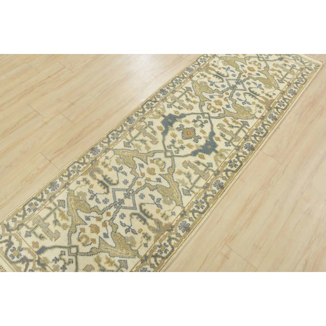 This traditional tribal Oushak runner rug is hand-knotted with an all-wool pile on a cotton foundation. This rug is new...