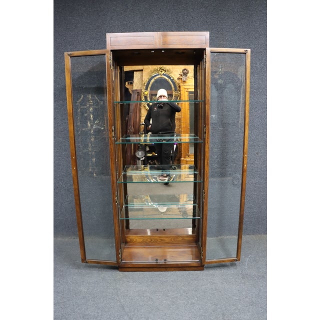 Henredon “Scene One” curio cabinet in oak, made in Morganton, North Carolina. Features full glass doors with inset brass...