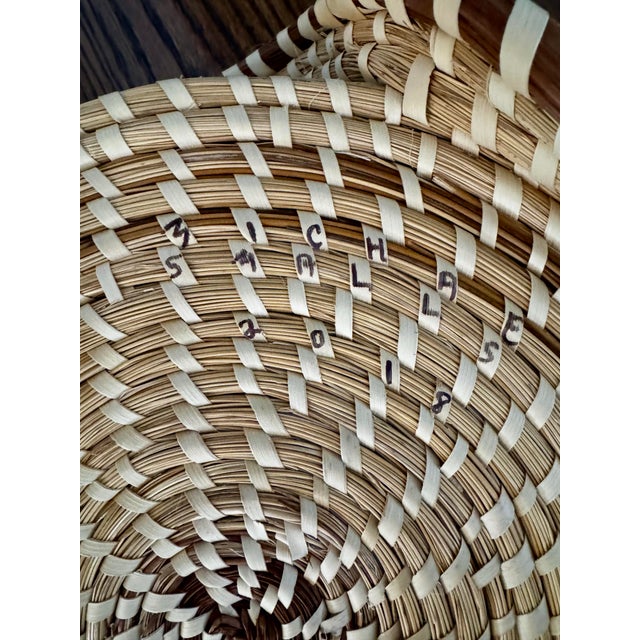 Authentic handwoven sweetgrass basket created by Gullah Geechee artisan Michael Smalls, signed and dated 2018. This piece...