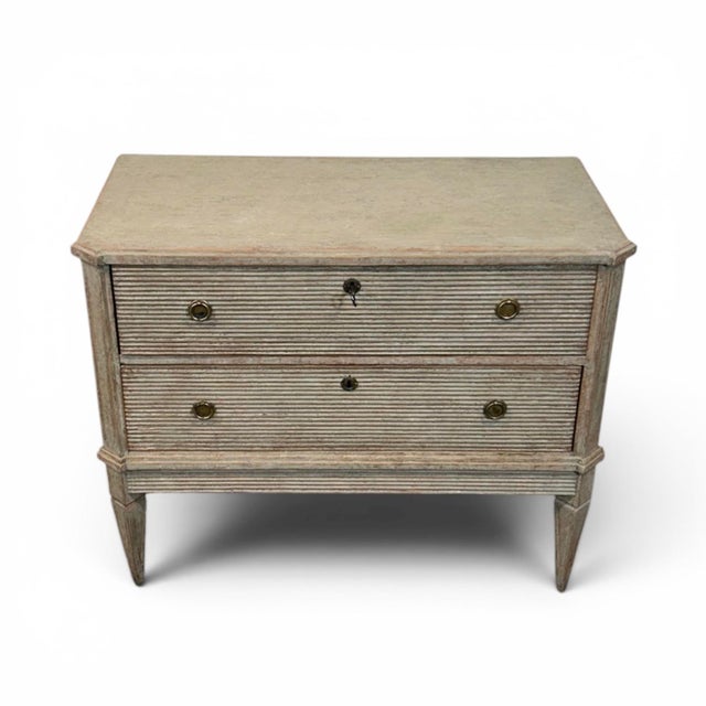 A classic pair of Gustavian-style chests of drawers in a grey finish with a beautiful patina. The corners are chamfered...