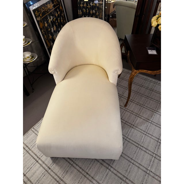 Elegant chaise by Donghia, a John Hutton Design upholstered in a warm creme velvet Fabric. Delicate arms with button...
