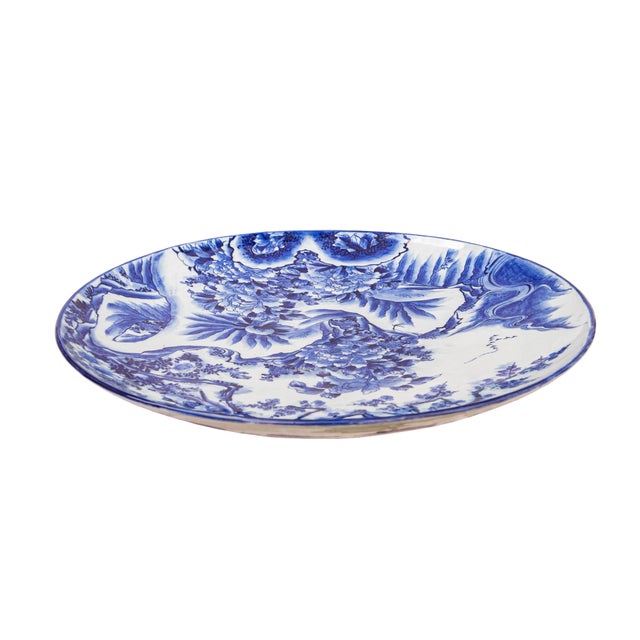 A large-scale Chinese blue and white porcelain charger in the Kangxi taste, decorated with peacocks amid flowering...