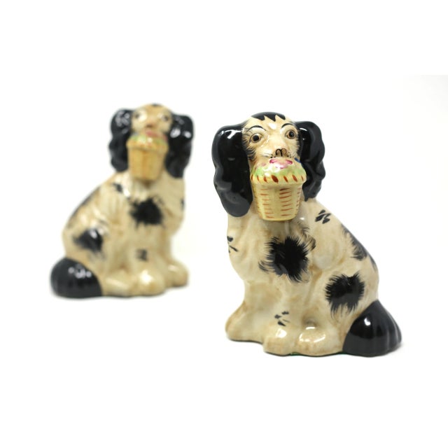 A set of two hand-painted ceramic figures of Cavalier King Spaniels, each posed with a basket of flowers. Excellent...