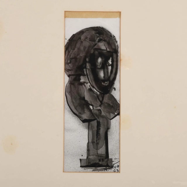 This Framed Signed J. Akston "African Fetish, 1963" Enamel on Paper Painting is a striking piece that captures the essence...