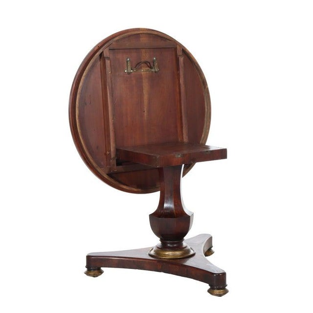 This distinguished English Regency tilt-top table, crafted from rich rosewood, dates to approximately 1840. The circular...