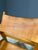 A distinctive pair of vintage wooden armchairs featuring clean, angular frames, straight legs, and gently sloping...