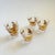 A set of 5 mid century shot glasses. Each glass decorated with metallic gold and white fan design. Each glass measures...