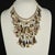 Waterfall bib necklace filled with dangles comprised of mother of pearl discs, small shells, Swarovski crystal beads, and...