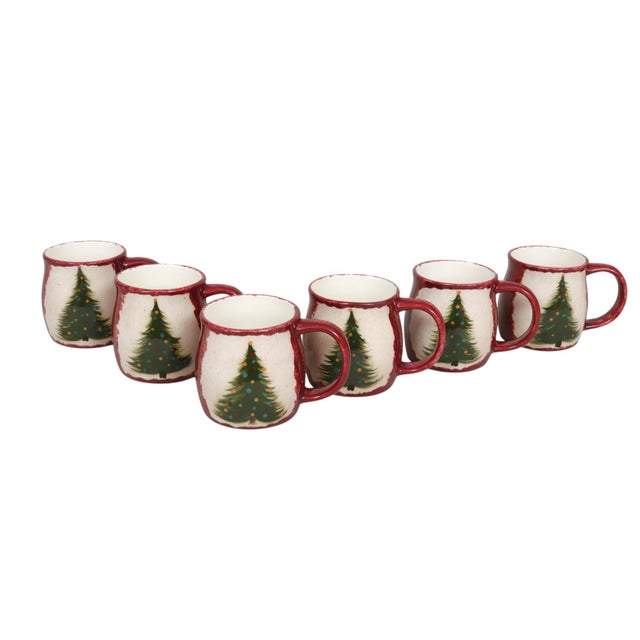 A set of six ceramic festive Christmas mugs. Each is individually hand-painted with a brushed green Christmas tree. Red,...