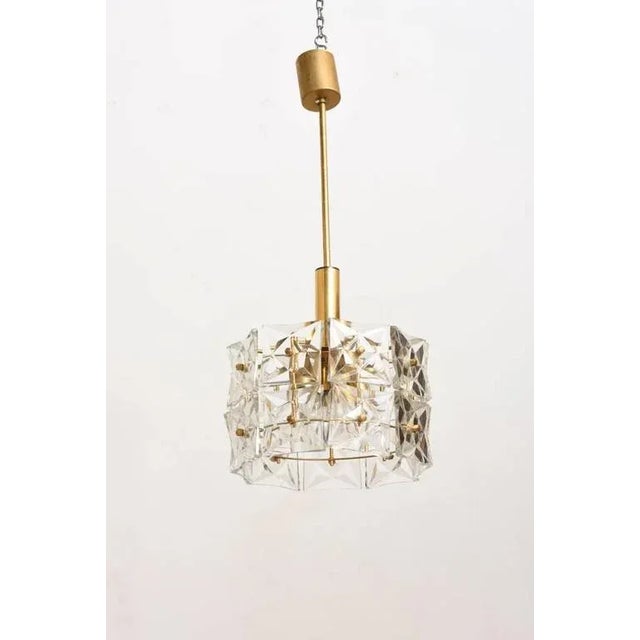 A Mid-Century Modern faceted crystal chandelier with brass fittings designed by Kinkeldey. Hand-cut faceted glass prisms...