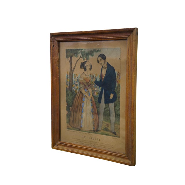 Mid 19th Century Hand Colored Lithograph. Titled Le Cadeau which translated to gift. The artwork shows a well dressed...