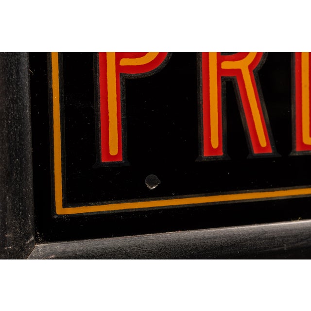 Early 20th-century pharmacy trade sign featuring reverse-painted graphics on glass and bold "PRESCRIPTIONS" lettering....