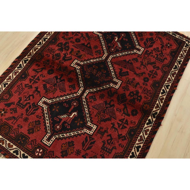 An authentic vintage tribal Shiraz rug hand-knotted with fine wool and natural dyes. This nomadic rug features geometric...
