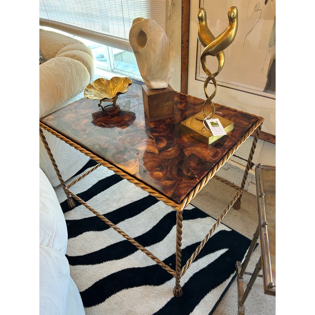 Twisted brass end table with a warm patina having a tortoise shell colored tessellated coconut shell top. Legs terminate...