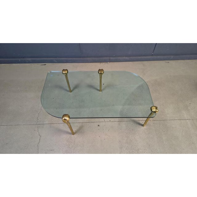 Elegant 4 legged solid brass coffee table with a clear glass top. Cool assymetric design. Very much in the style of Peter...