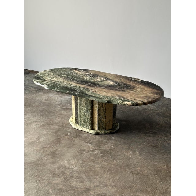 Carved from a dramatic slab of green Cipollino Ondulato marble, this oval coffee table is defined by sweeping bands of...