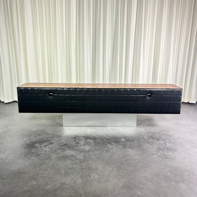 Modernist sideboard composed of a teak veneer frame and black lacquered sides, closed by a drop-down door covered in...