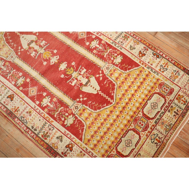 Midcentury Turkish rug with a double column scroll prayer motif on a deep red ground surrounded by an ivory border....