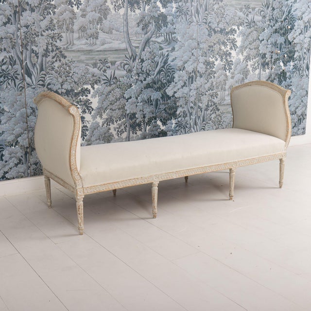 An elegant Gustavian period daybed from the 19th century wearing original paint and newly upholstered in linen. This piece...