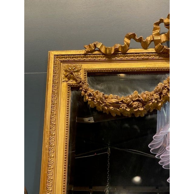This item is a luxurious 19th century French Louis XVI giltwood mirror, featuring intricate detailing and a stunning gold...