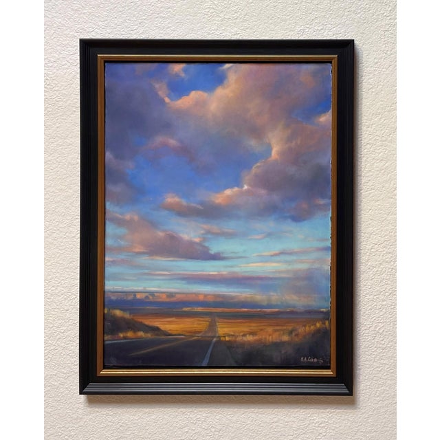 This pastel work captures a vast, open landscape under a dramatic sky filled with vibrant clouds that transition from warm...