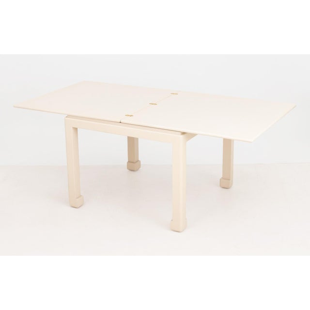 James Mont Style White Painted Extending Dining Table. Extended: 30.25" H x 76" W x 38" D; closed: 31" H x 38" W x 38" D....