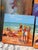 In Time Out I and Time Out II, Godfrey Afebuame paints simple, bright scenes of people relaxing at the beach. Using thick...