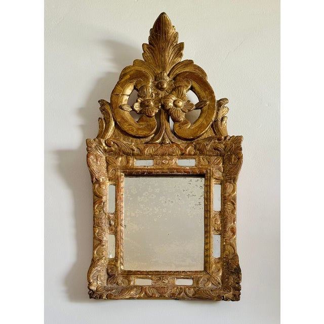 A gilded wood parclose mirror. The central mirror pane surrounded by eight smaller panels. French 18th century.