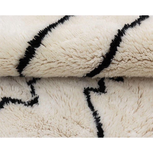 Elegant hand-knotted wool rug with a striking Midnight Black abstract pattern on an Ivory base. A versatile piece that...