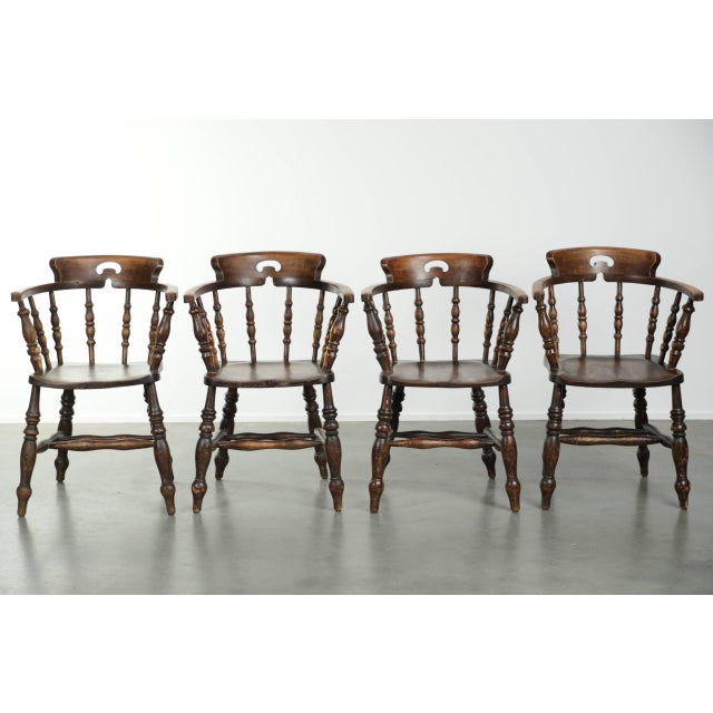 We are offering this set of four antique English wooden pub/captain chairs from the late 19th century, featuring character...