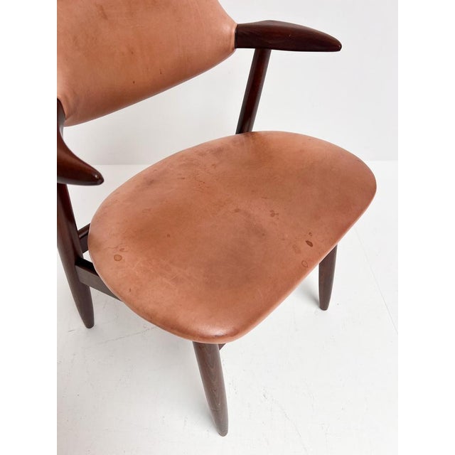 This typical vintage cowhorn chair is recognizable by its armrests shaped like a cowhorn. This distinctive wooden chair is...