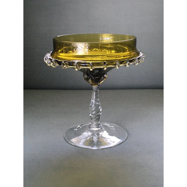 A vintage olive green footed compote dish with a delicately ruffled edge and a clear faceted glass stem. This dish is a...