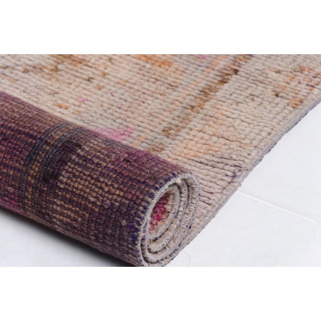 This is a vintage Turkish Oushak rug from the Mid 20th Century. The piece was hand-knotted.