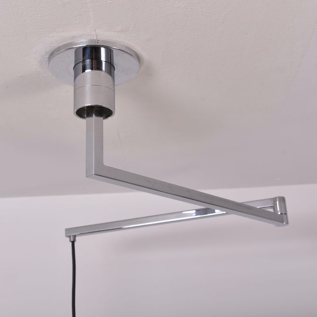 Chrome-plated ceiling lamp from 1969 with two-piece metal arm, which can sprawl and rotate around the mounting. The bell...