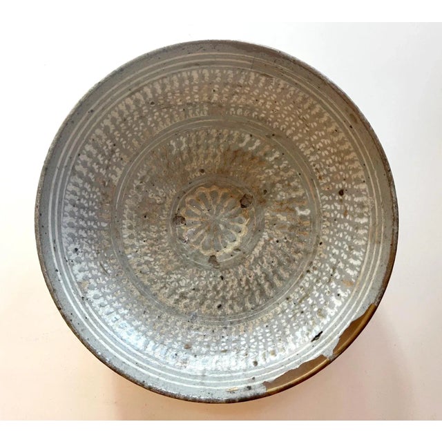 A Korean ceramic shallow bowl on ring foot in the classic Buncheong (or Punch'ong) style from early Joseon Dynasty circa...