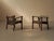 Pair of solid oak armchairs with a low, understated profile and clean lines. The simple frame is made of straight uprights...