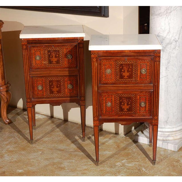 Two, inlaid, two-drawer commodini on tapered legs with white, Carrara marble tops from Naples.