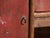 This antique red-lacquered low cabinet in elm is a Chinese kang cabinet with three drawers, two side doors and a shelved...