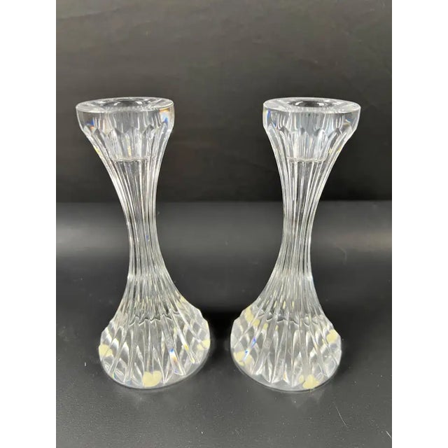 An elegant pair of Baccarat Masséna crystal candlesticks, finely crafted in France and bearing the acid-etched Baccarat...