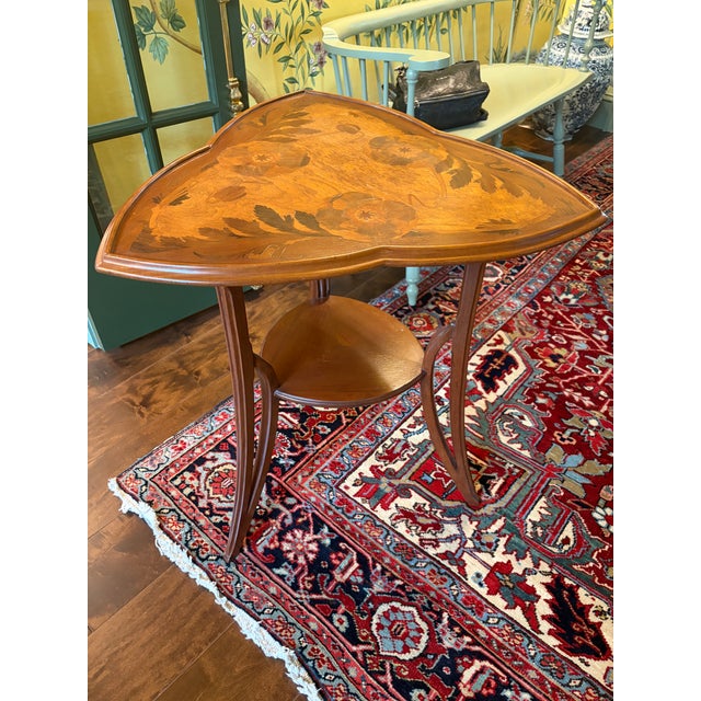 A dark brown trefoil table inlaid with poppies by one of the most important artists of the french art noveau movement,...