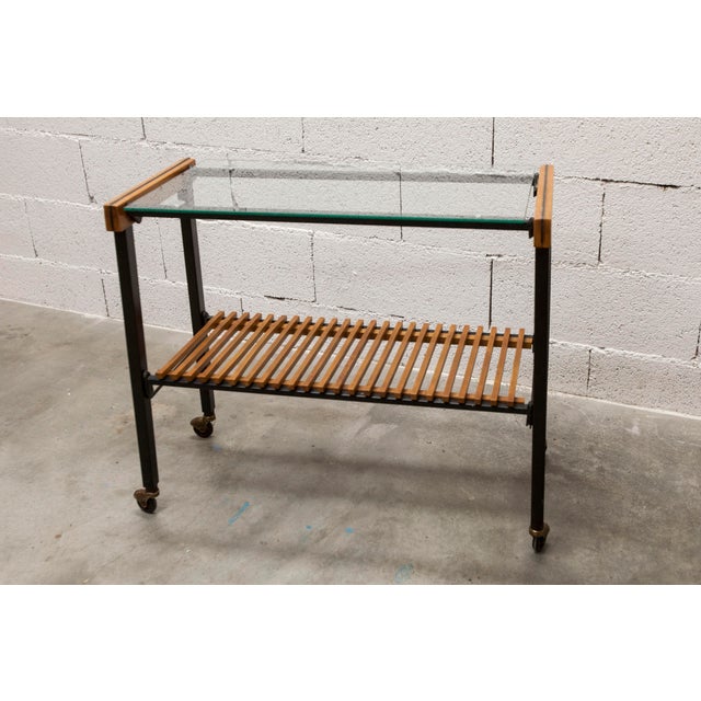 1960s teak wood and black metal hi-fi cabinet on casters with a glass top. It's in superb condition, cleaned after...