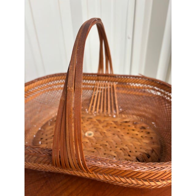 A beautifully handwoven vintage bamboo gathering basket retaining its original Hunan Products “Made in China” label....