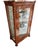 Single-door display cabinet with glass shelves and damask bottom.
