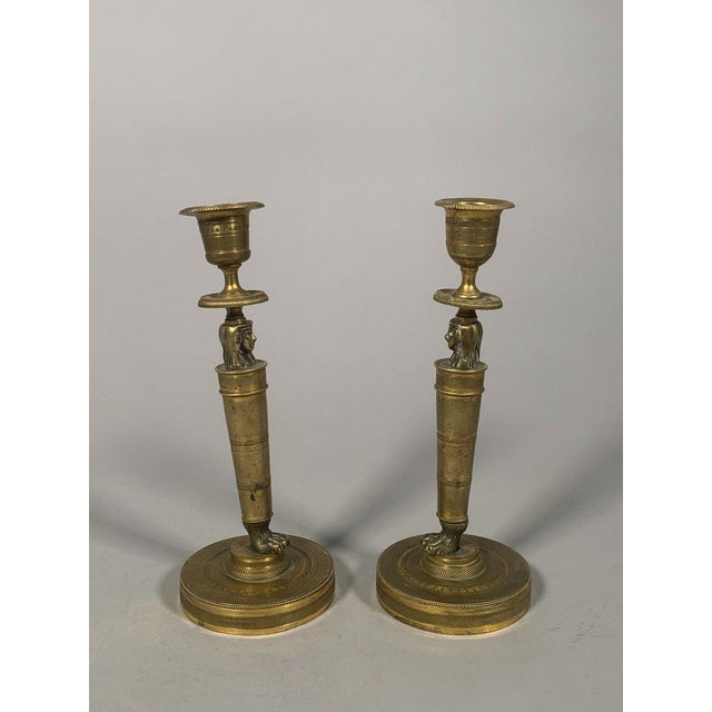 Pair of gilt bronze candlesticks, Empire period, known as "Return from Egypt" style, early 19th century. The stem is...