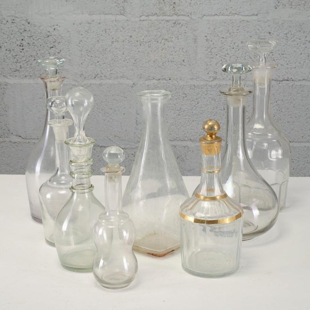 This set of eight vintage glass bottles and decanters, dating back to the mid-20th century, represents an interesting...