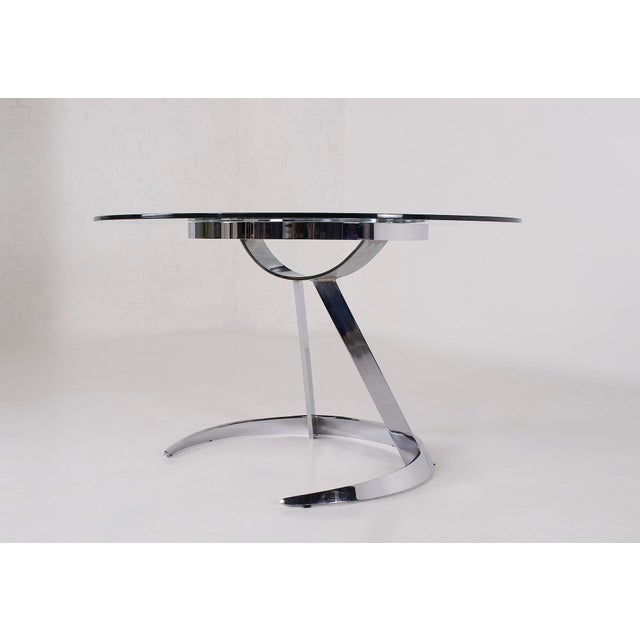 Chromed steel and clear glass table, "Scimitar" model, by Boris Tabacoff for Mobilier Modulaire Moderne. Made in the...