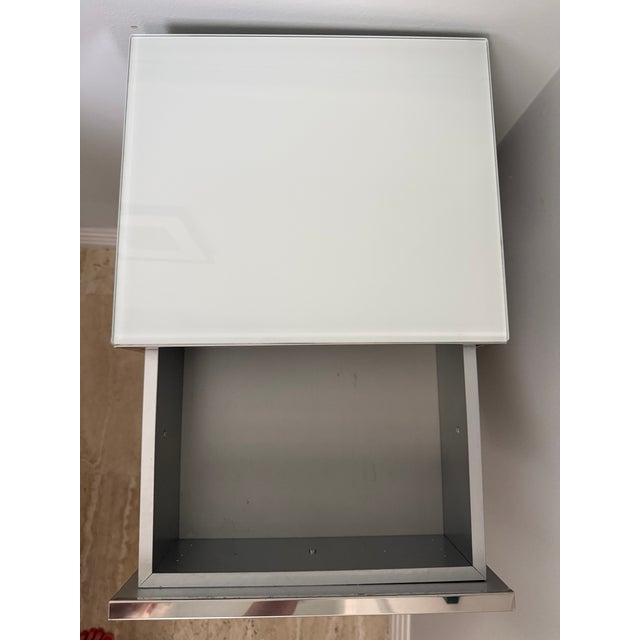 Waterworks freestanding cabinet with two shelves and a drawer. Brass frame with Nickel finish and a glass top. On Casters.