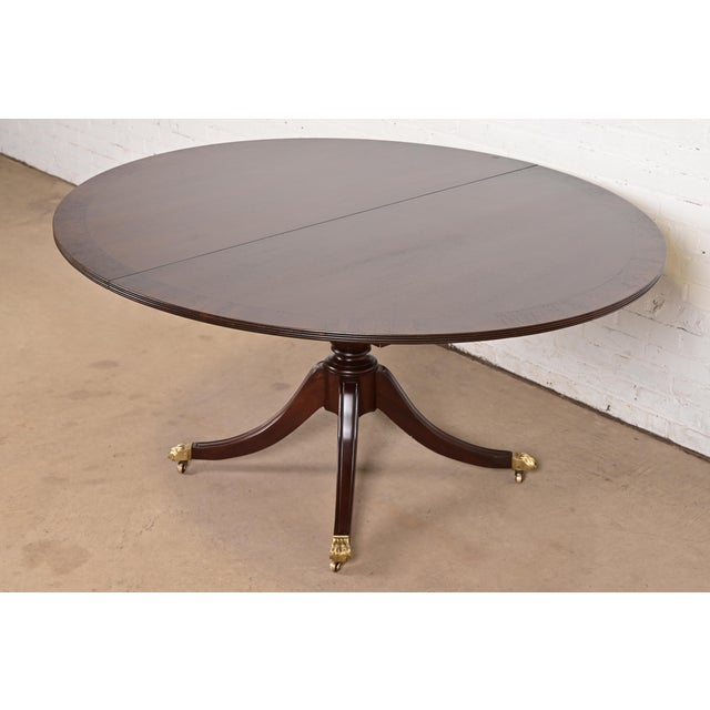 An exceptional Georgian or Regency style pedestal extension dining table In the manner of Baker Furniture USA, Circa 1960s...