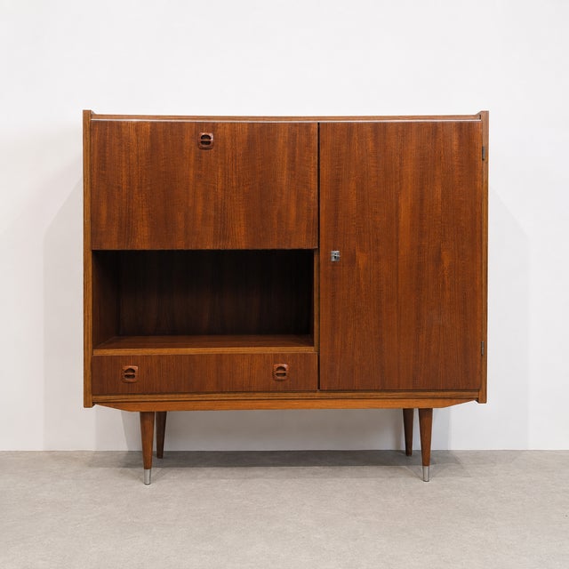 Vintage mid-century highboard combining a drop-down bar / writing compartment, decorative open niche, lower drawer and a...